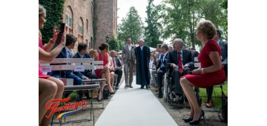 feestloper zandkleurigeloper naast kerk